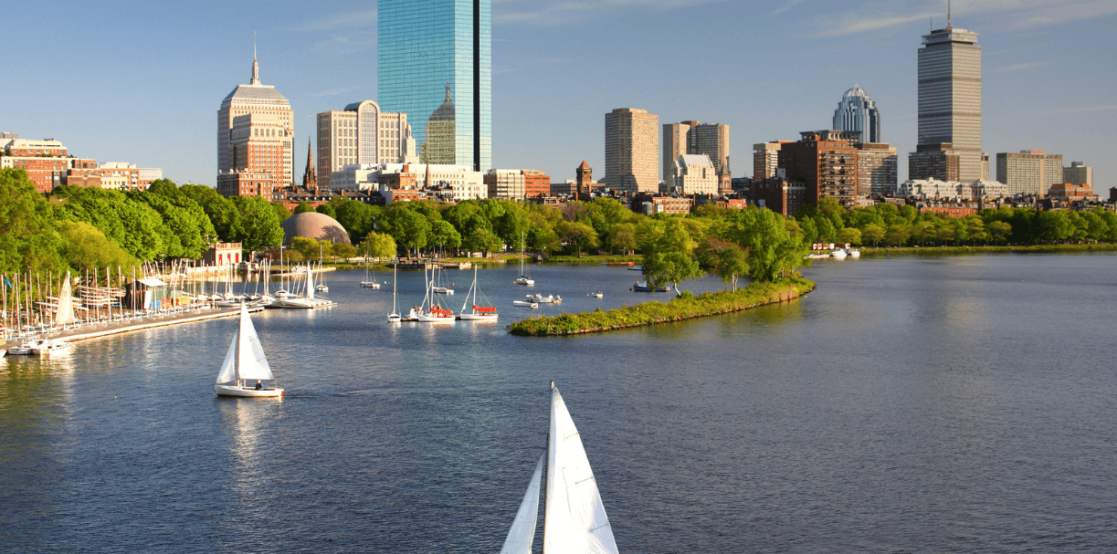 Boston skyline seen across the Charles River with sailboats on the water