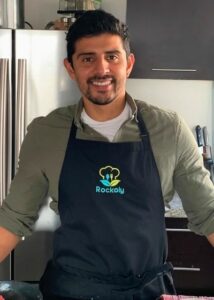 Chef Arturo smiling in his kitchen wearing a navy Rockoly apron