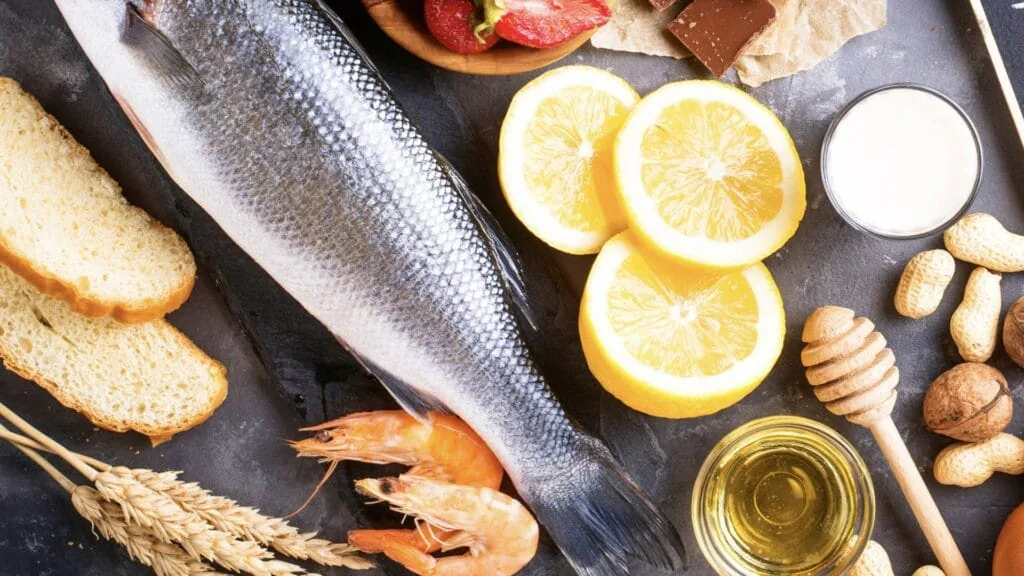 Overhead spread of common food allergens including fish, shrimp, bread, wheat, peanuts, milk and honey