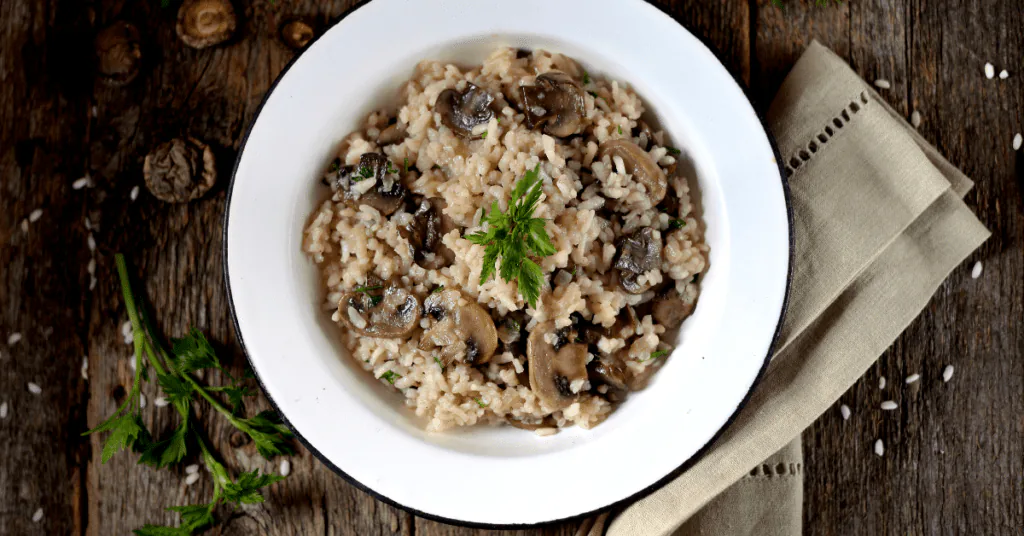 Bowl of creamy mushroom risotto garnished with fresh parsley