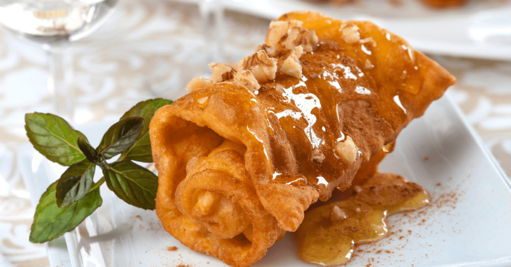 Greek diples, fried pastry rolled and drizzled with honey, chopped walnuts and cinnamon