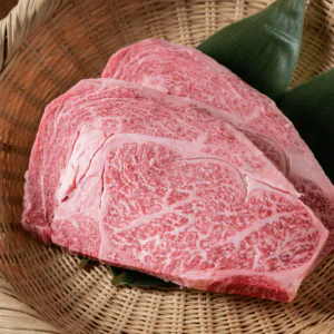 Two thick slices of heavily marbled wagyu beef resting in a woven basket