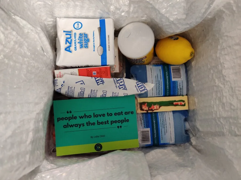 Open meal kit box of baking ingredients with a card quoting Julia Child: people who love to eat are always the best people