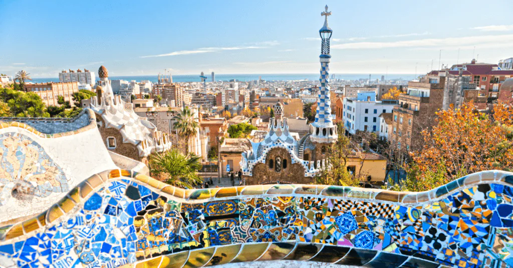 Mosaic-tiled terrace at Park Güell looking out over the rooftops of Barcelona and the sea