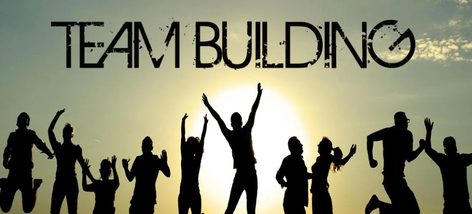 Banner reading Team Building over silhouettes of people jumping against a sunset