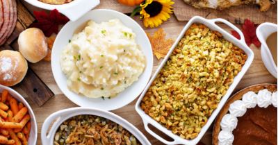 Thanksgiving table with mashed potatoes, stuffing, green bean casserole, rolls, carrots and pumpkin pie