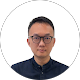 Owen Su wearing glasses and a dark collared shirt against a plain white background