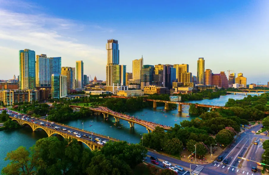 Austin skyline and Lady Bird Lake with bridges crossing the water at sunset