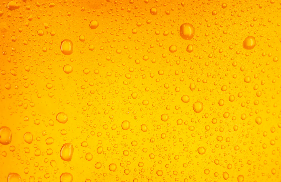 Close-up of condensation droplets on an amber beer-colored surface