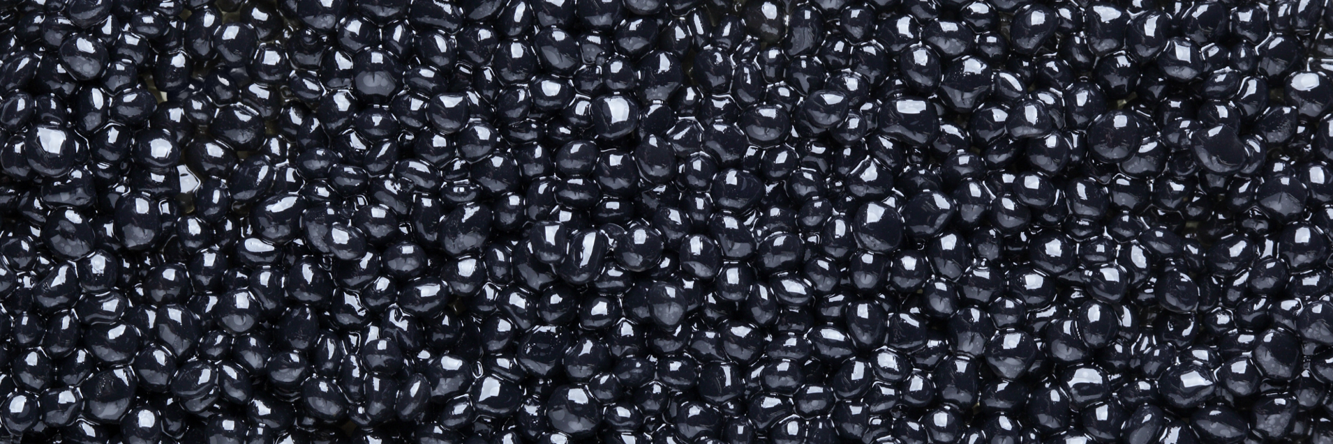 Close-up of glossy black caviar pearls filling the frame