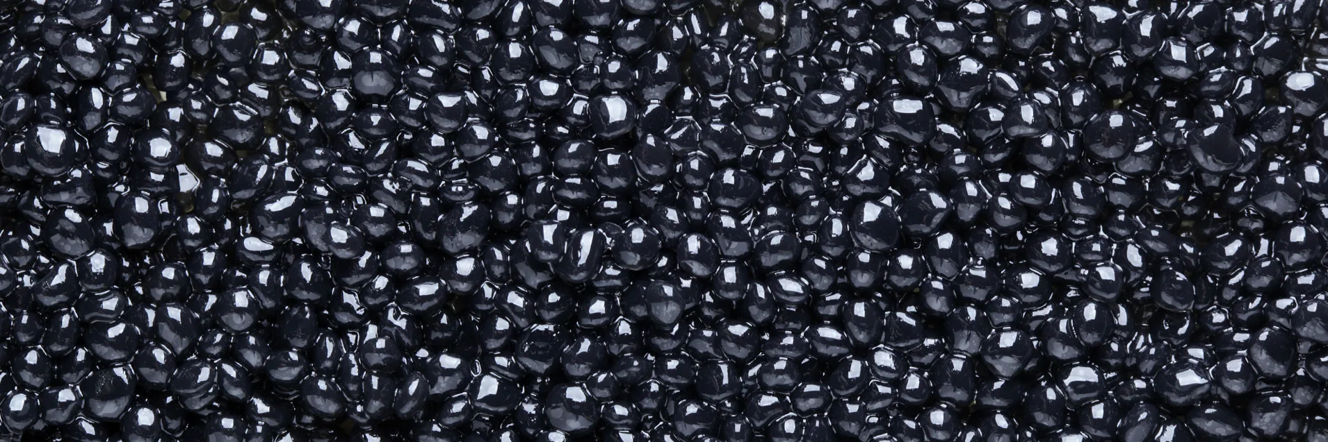 Close-up of glossy black caviar pearls filling the frame