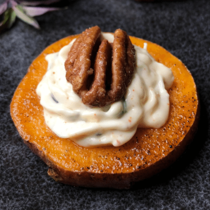 Candied sweet potato round topped with whipped goat cheese and a toasted pecan