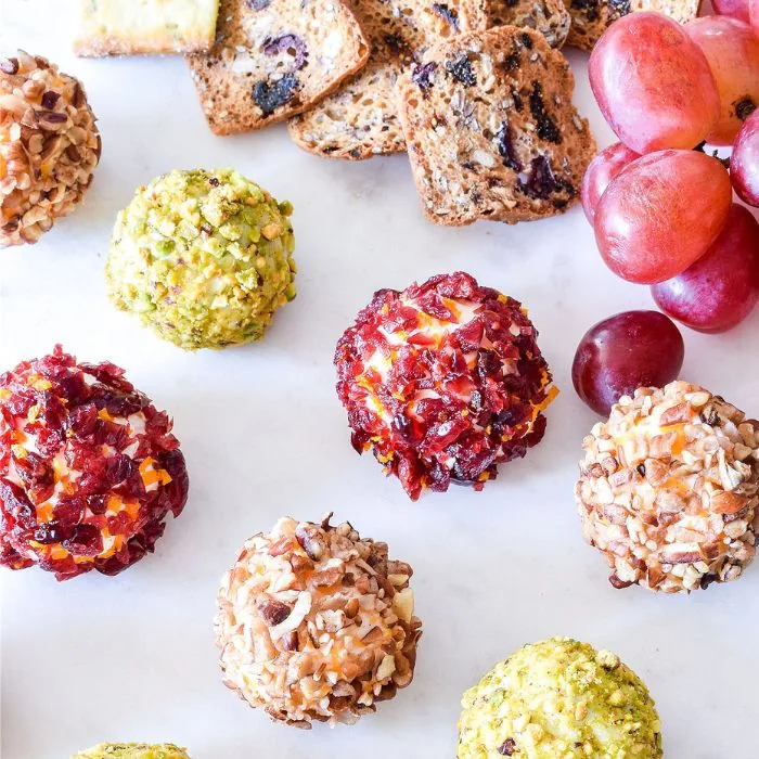 Cheese truffles rolled in dried cranberry, pistachio and pecan, with seeded crackers and red grapes
