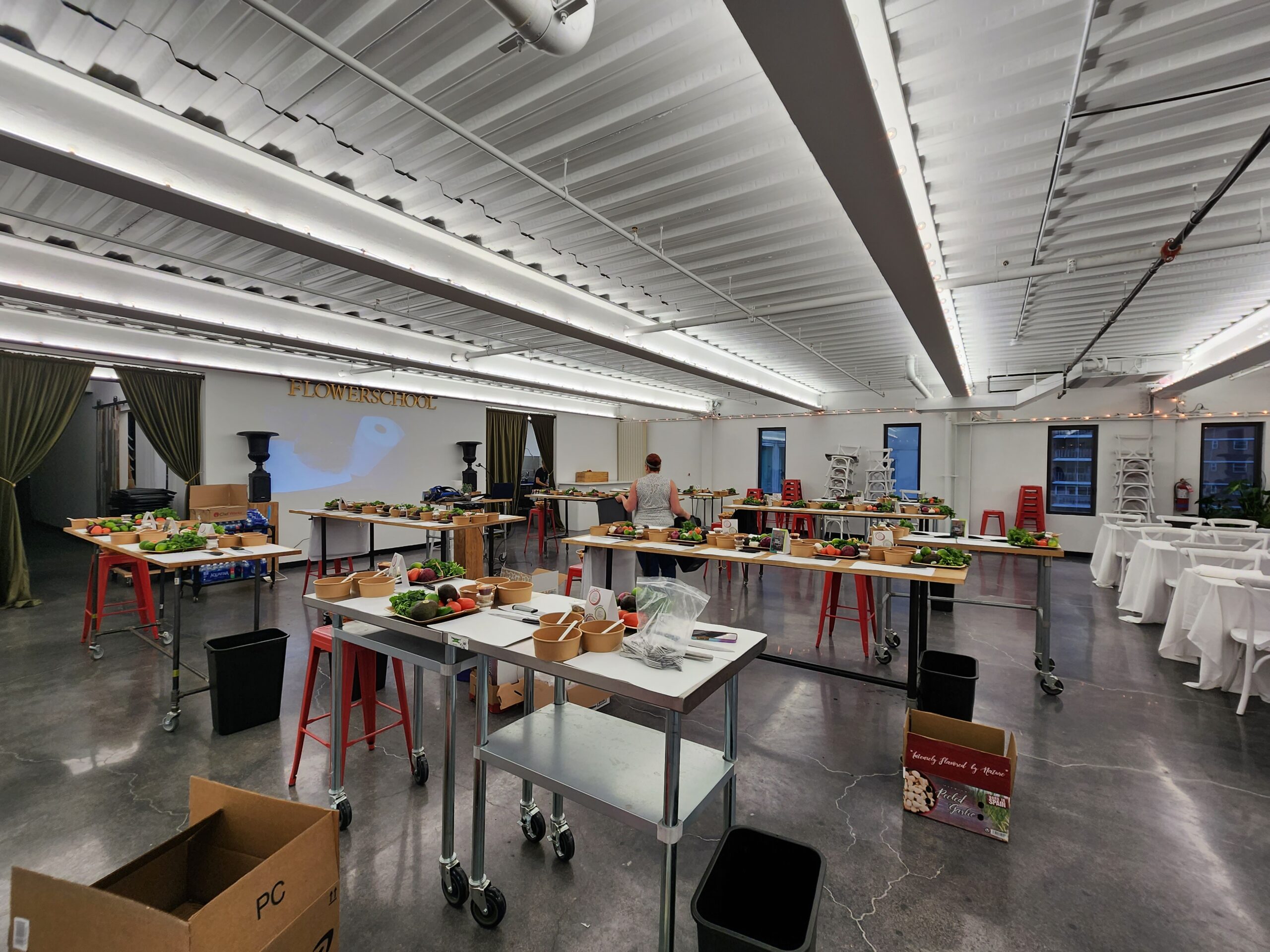 Loft event space set with cooking stations, ingredient trays and stools before guests arrive