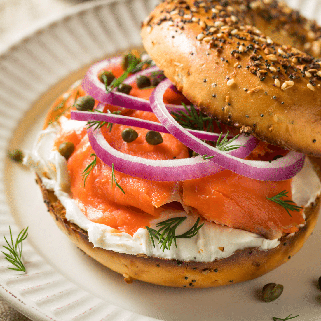 Everything bagel piled with smoked salmon, cream cheese, red onion rings, capers and dill