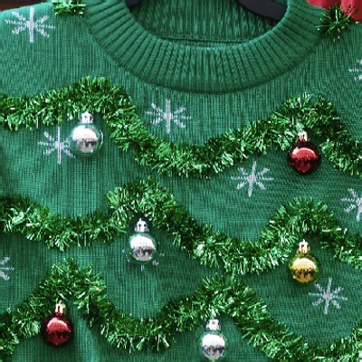 Green Christmas sweater trimmed with tinsel, baubles and snowflakes