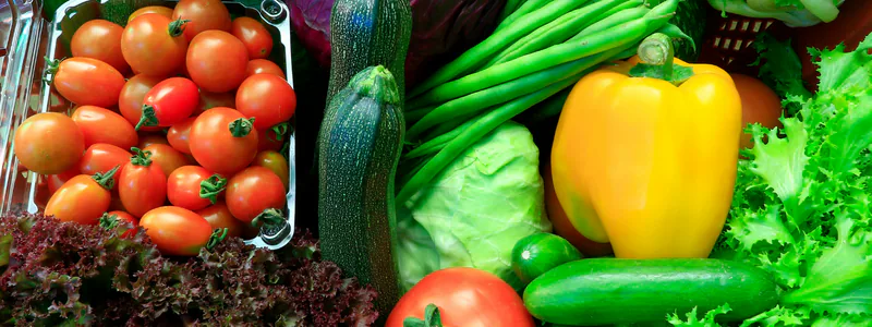 Close-up of fresh produce including cherry tomatoes, zucchini, green beans, yellow pepper and lettuce