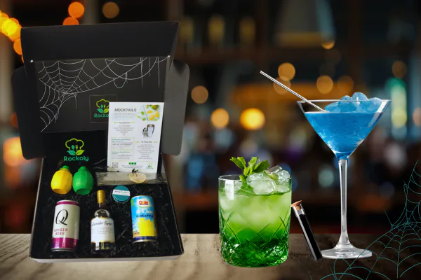 Halloween happy hour kit box with mini spirit bottles and recipe cards beside green and blue cocktails