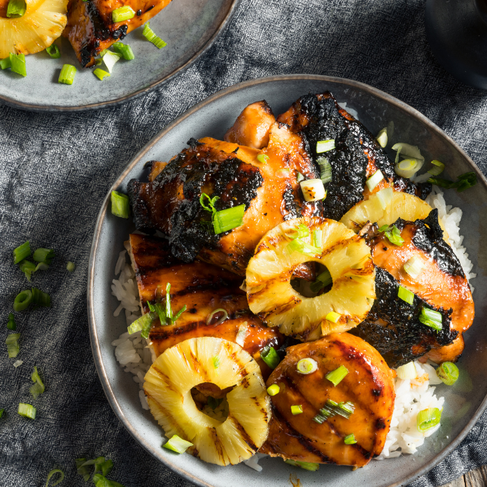 Glazed huli huli chicken with grilled pineapple rings and scallions served over white rice