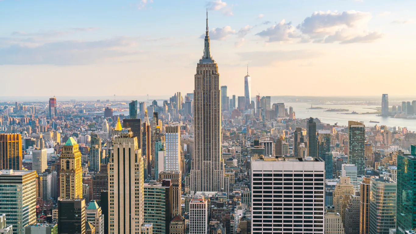 Manhattan skyline in warm light with the Empire State Building rising at the center