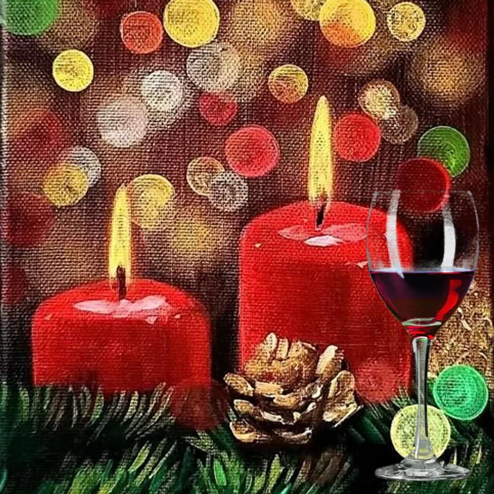 Glass of red wine in front of a painting of two lit red candles, a gold pine cone and evergreen under glowing bokeh lights