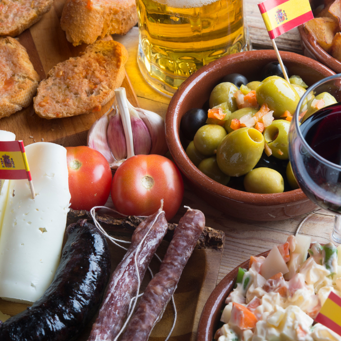 Spanish tapas spread with marinated olives, cured chorizo, cheese, tomato bread and a glass of beer