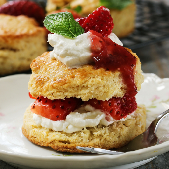 Strawberry shortcake biscuit layered with whipped cream and strawberries and topped with mint