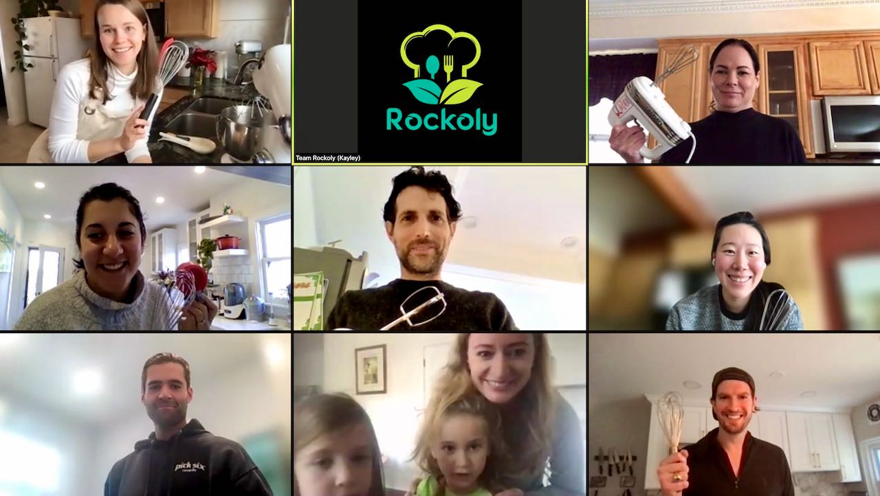 Nine people on a video call holding up whisks and hand mixers during a virtual baking class